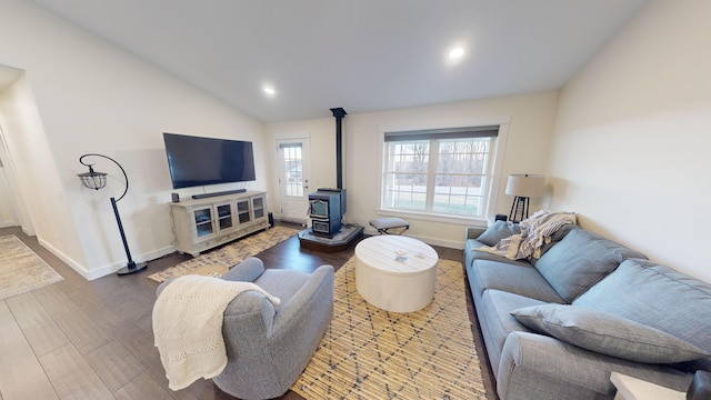 living room with hardwood / wood-style floors, lofted ceiling, and a wood stove