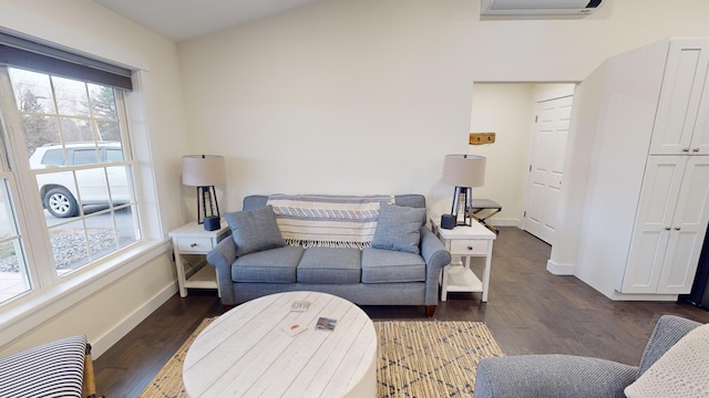 living room featuring a wall mounted AC, dark hardwood / wood-style floors, and a wealth of natural light