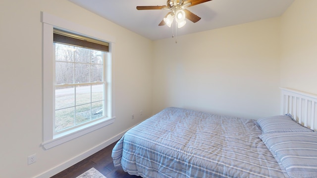 bedroom featuring multiple windows, ceiling fan, and dark wood-type flooring