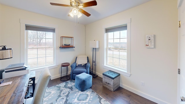 living area featuring a wealth of natural light, dark wood-type flooring, and ceiling fan