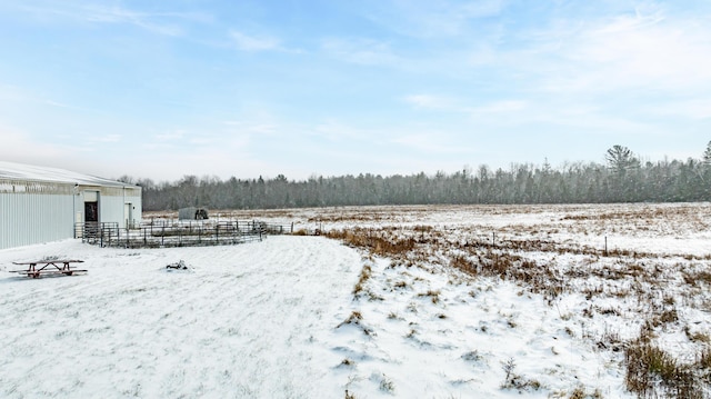 yard covered in snow featuring an outbuilding and fence