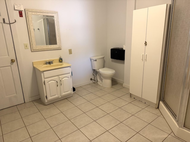 bathroom with tile patterned flooring, vanity, toilet, and an enclosed shower