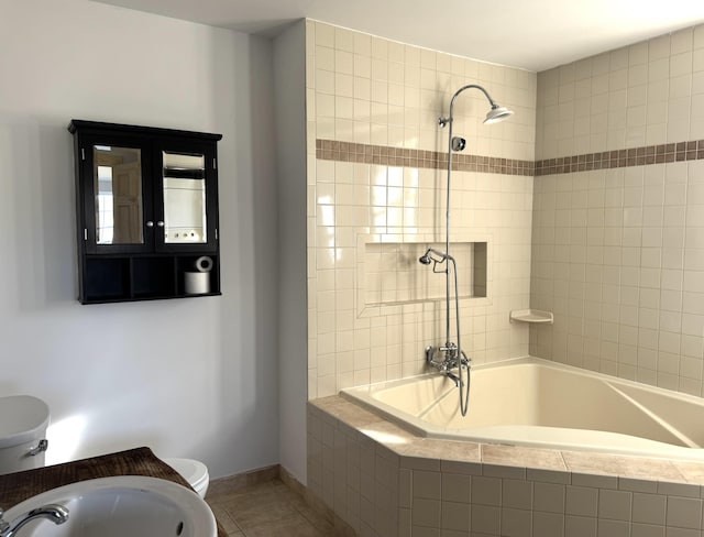 bathroom with tiled shower / bath combo, tile patterned floors, and toilet