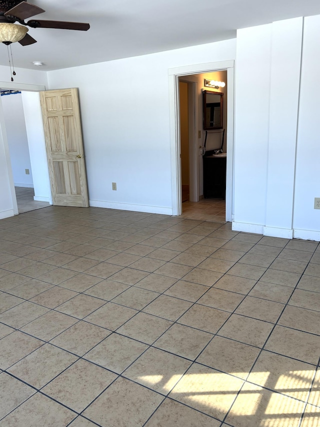 unfurnished room featuring light tile patterned floors, ceiling fan, and baseboards