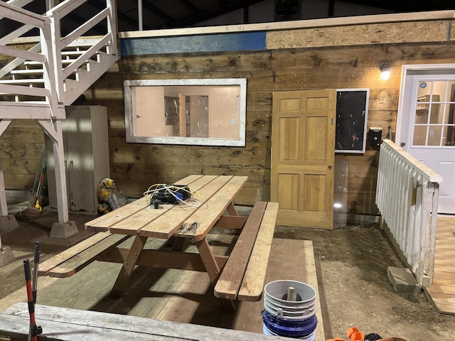 interior space with wood walls, stairway, and vaulted ceiling