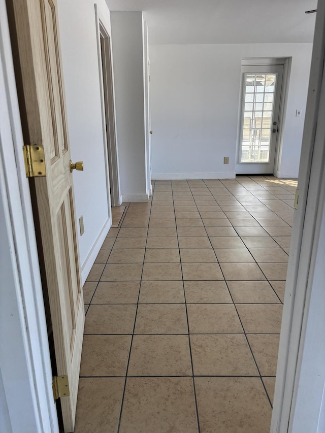 spare room with light tile patterned floors and baseboards