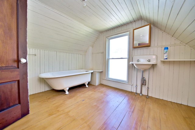 additional living space featuring light wood-type flooring, lofted ceiling, wooden ceiling, and wood walls