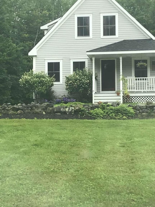 view of front of home with covered porch and a front lawn