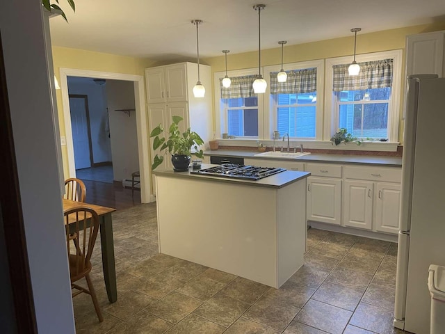 kitchen featuring sink, white cabinets, hanging light fixtures, and white refrigerator