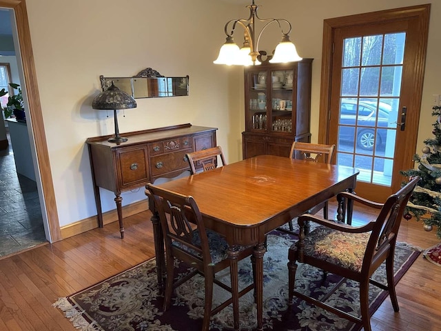 dining room with dark hardwood / wood-style floors and an inviting chandelier