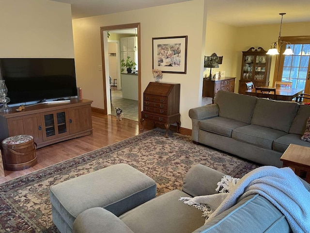 living room with hardwood / wood-style flooring and a notable chandelier