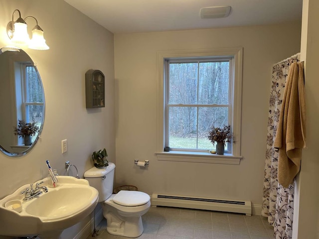 bathroom featuring sink, toilet, and baseboard heating