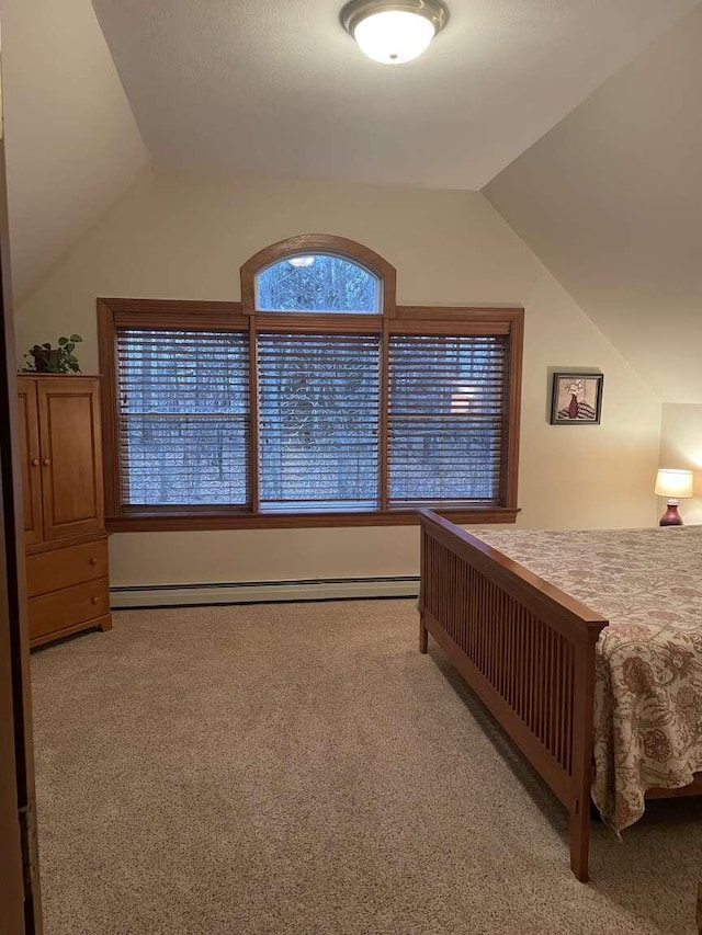 carpeted bedroom featuring baseboard heating and vaulted ceiling