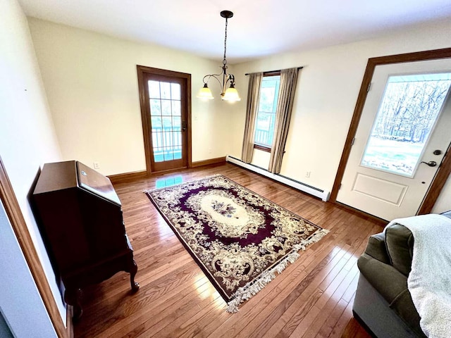 281 Danville Corner Rd, Auburn, ME 04210 - dining area featuring wood-type flooring, baseboards, a notable chandelier, and baseboard heating
