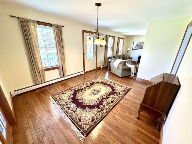 281 Danville Corner Rd, Auburn, ME 04210 - interior space featuring baseboards, a baseboard heating unit, wood finished floors, and an inviting chandelier