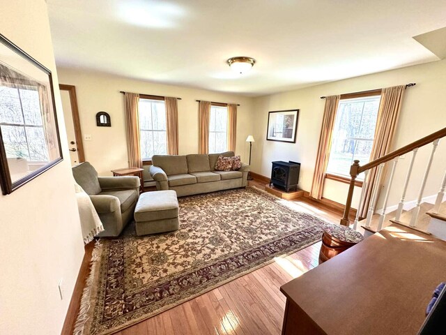 281 Danville Corner Rd, Auburn, ME 04210 - living room with stairway, a wood stove, wood finished floors, and a wealth of natural light