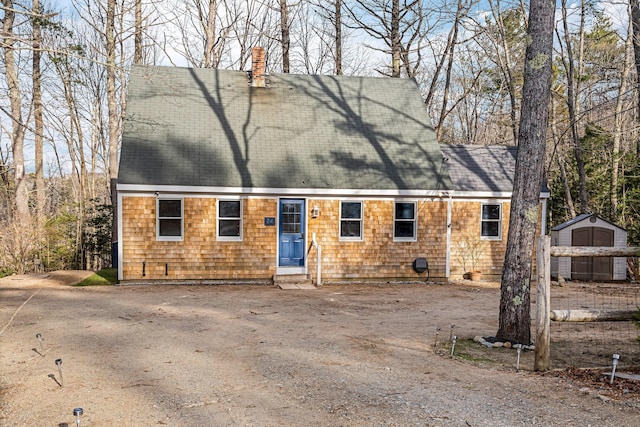 new england style home with a storage shed