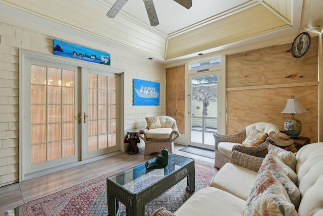 tiled living room featuring ceiling fan and french doors