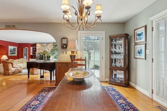 dining space with light wood-type flooring and a chandelier