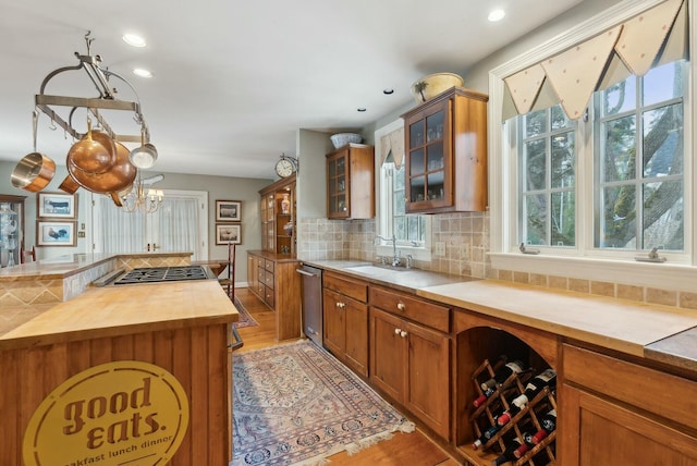 kitchen featuring wooden counters, appliances with stainless steel finishes, tasteful backsplash, hanging light fixtures, and sink