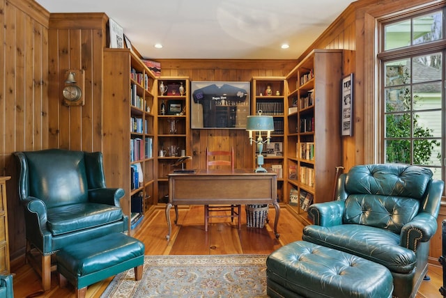 living area with hardwood / wood-style floors and wooden walls