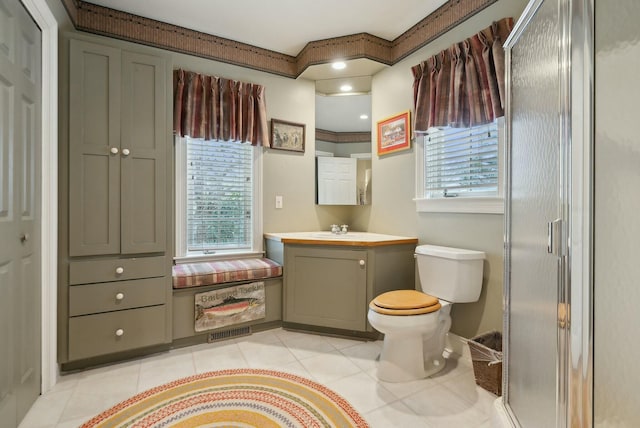 bathroom with toilet, a wealth of natural light, tile patterned flooring, and vanity