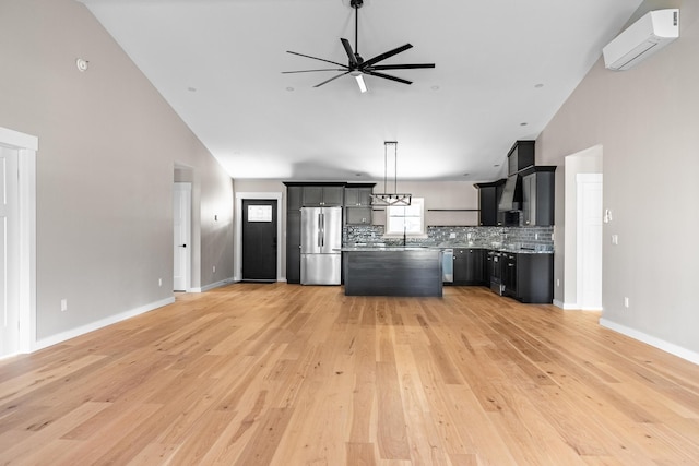 kitchen featuring light wood-type flooring, backsplash, stainless steel appliances, and a wall unit AC