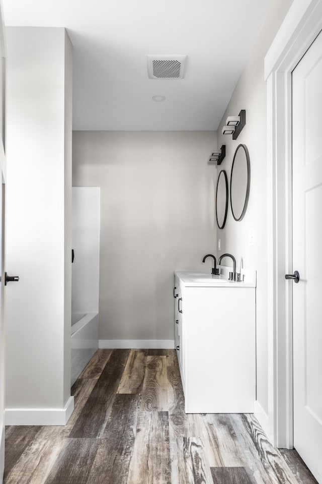 bathroom featuring shower / bath combination, vanity, and wood-type flooring