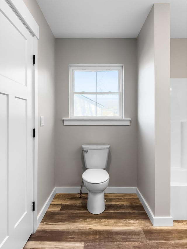 bathroom with hardwood / wood-style floors and toilet