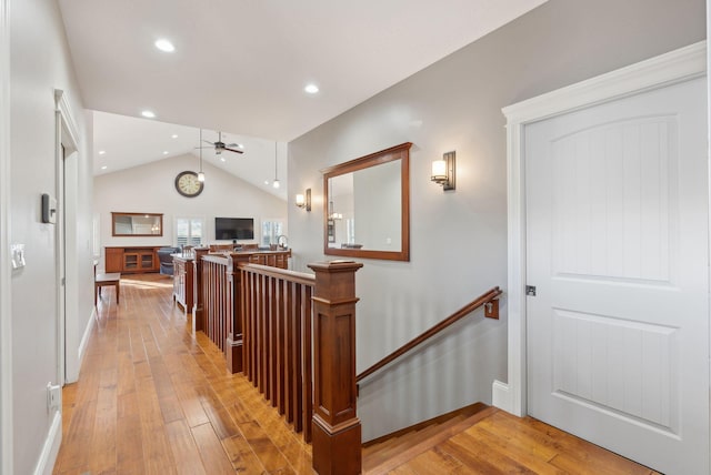 hallway featuring vaulted ceiling and light wood-type flooring