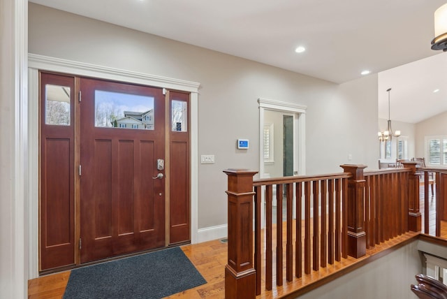 entryway with light wood-type flooring and a chandelier