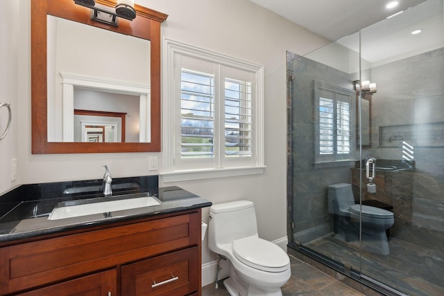 bathroom with vanity, toilet, and a shower with door