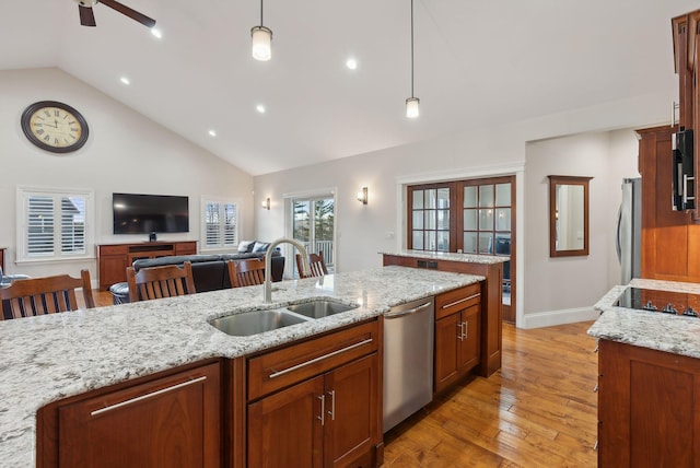 kitchen featuring light stone countertops, sink, decorative light fixtures, a breakfast bar, and appliances with stainless steel finishes