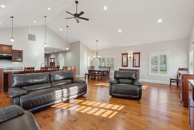 living room featuring light hardwood / wood-style floors, high vaulted ceiling, and a wealth of natural light