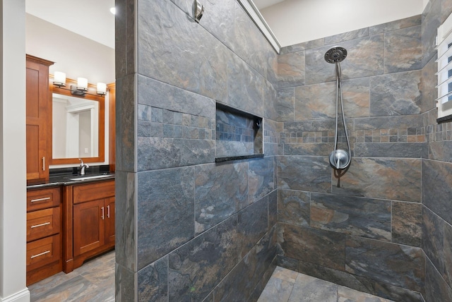 bathroom featuring a tile shower and vanity