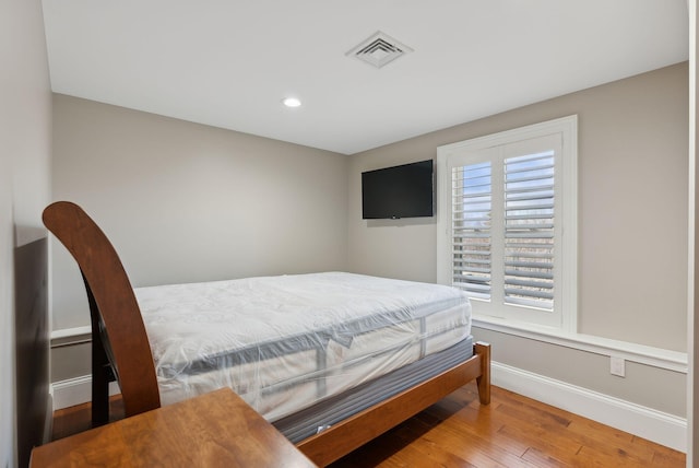 bedroom featuring hardwood / wood-style flooring and multiple windows