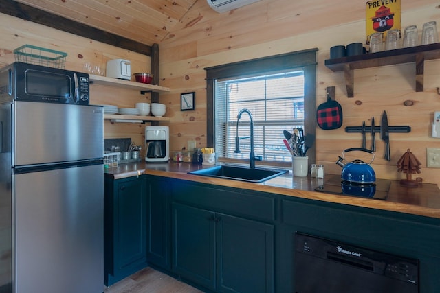 kitchen with lofted ceiling, black appliances, blue cabinets, sink, and wooden walls