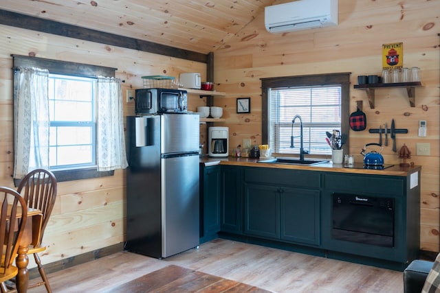 kitchen featuring sink, stainless steel refrigerator, and wood walls