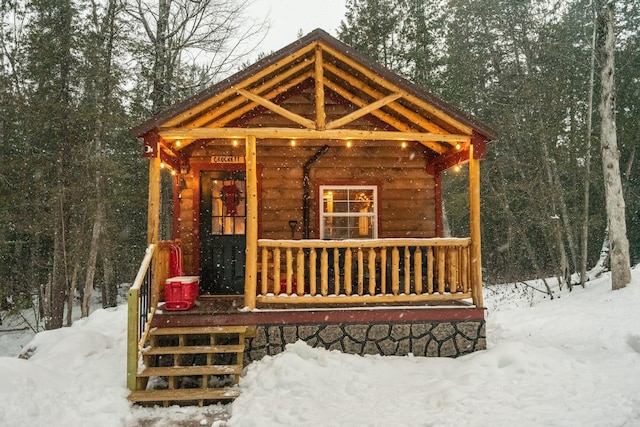 snow covered structure featuring a porch