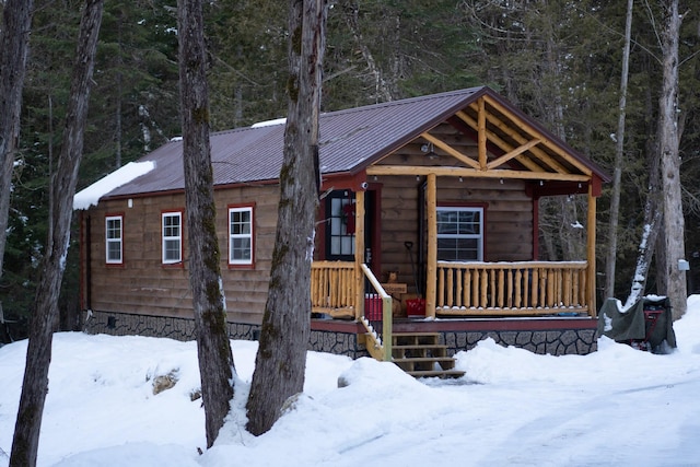 log cabin featuring covered porch