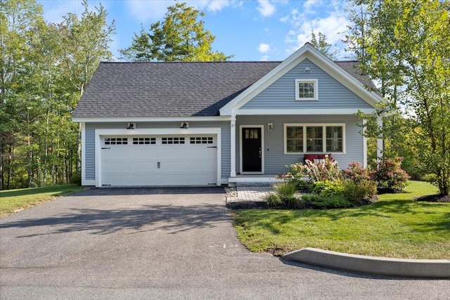 view of front of home with a front yard, a garage, and covered porch