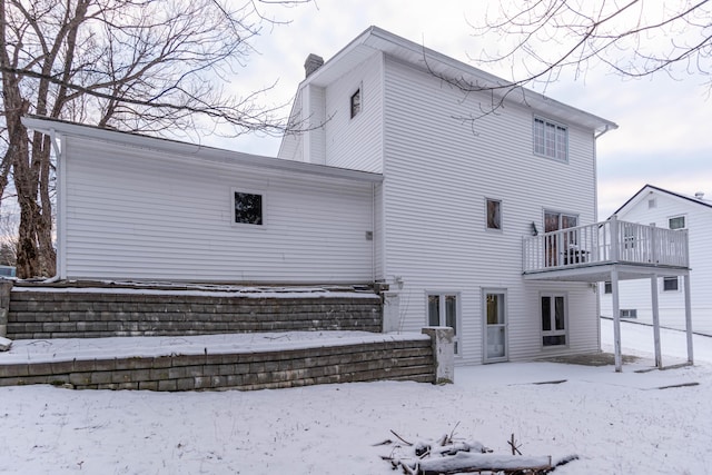 snow covered property with a balcony