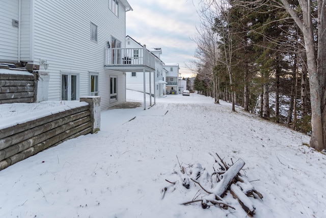 snowy yard featuring a balcony