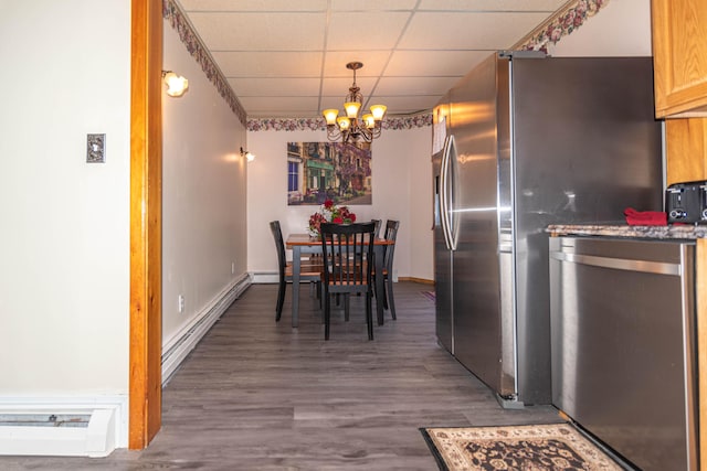 kitchen featuring a paneled ceiling, a baseboard heating unit, dark hardwood / wood-style floors, appliances with stainless steel finishes, and a notable chandelier