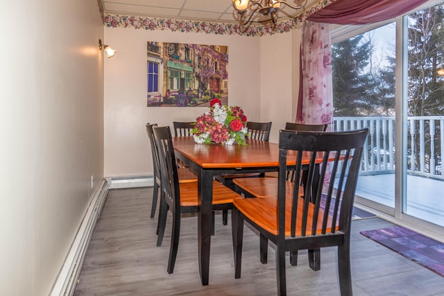 dining area with a chandelier, baseboard heating, and a wealth of natural light