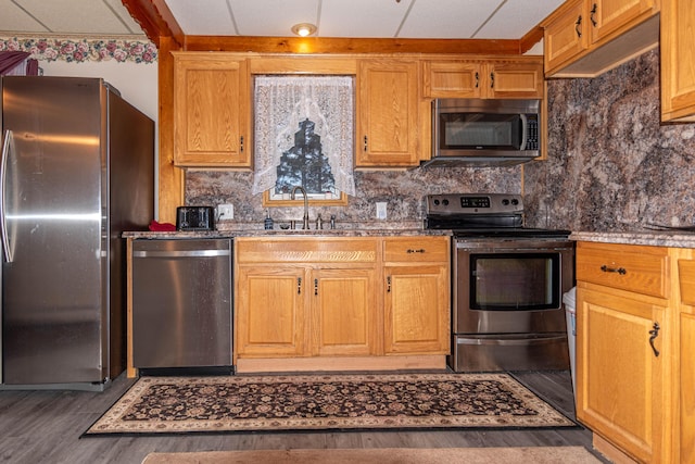 kitchen featuring backsplash, sink, appliances with stainless steel finishes, and dark wood-type flooring