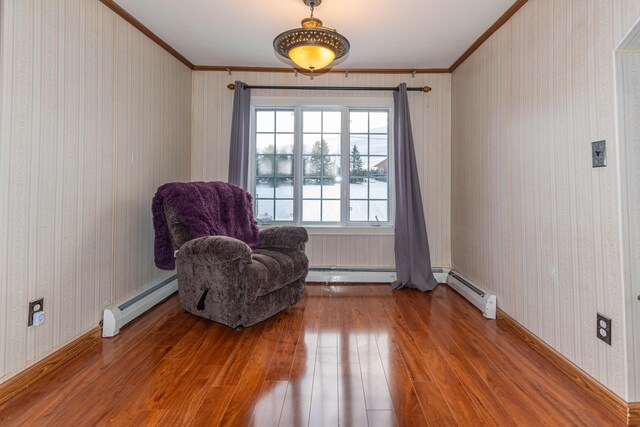 sitting room featuring hardwood / wood-style flooring, crown molding, and a baseboard heating unit