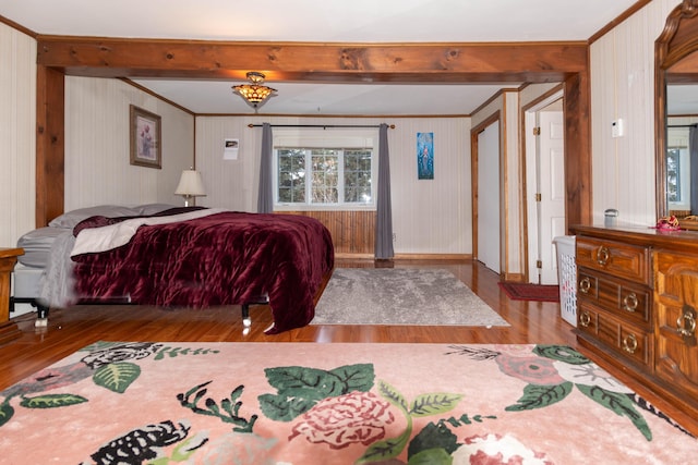 bedroom with beamed ceiling and light hardwood / wood-style floors