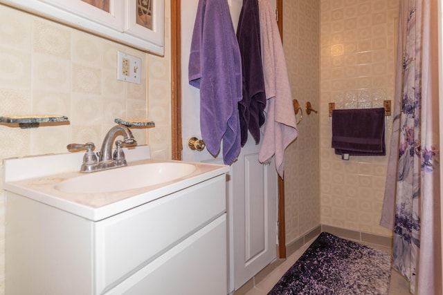 bathroom featuring vanity and tile walls