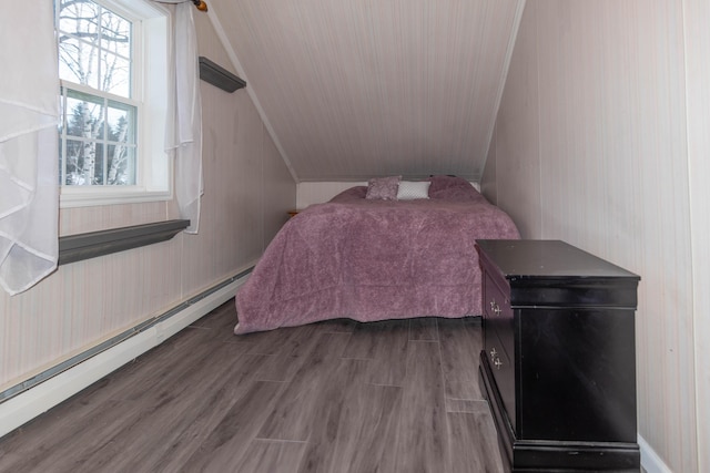 bedroom featuring baseboard heating, multiple windows, lofted ceiling, and dark hardwood / wood-style floors